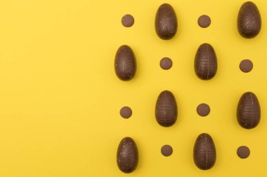Parlak sarı arka planda çikolata Paskalya yumurtası. Paskalya Holi