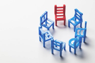 Circle of chairs with one odd one out.  clipart