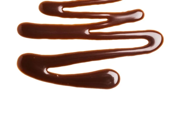 Molho de caramelo de chocolate ondulação em um fundo branco liso — Fotografia de Stock