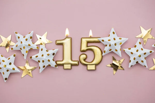 Numero 15 candela d'oro e stelle su sfondo rosa pastello — Foto Stock
