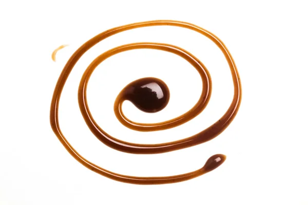 Sauce au caramel au chocolat tourbillonnant sur fond blanc uni — Photo