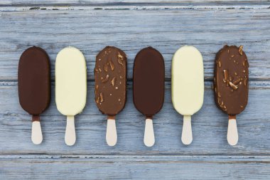 Ahşap bir arka plan üzerinde çikolatalı dondurma lollies.