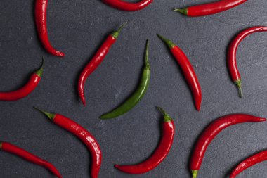 Koyu bir kayrak backgroun bir yeşil ile Kırmızı taze biber