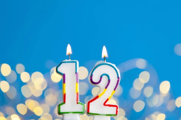Nummer 12 verjaardag viering kaars tegen een felle lichten een — Stockfoto