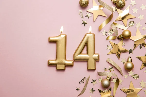 Number 14 gold celebration candle on star and glitter background — Stock Photo, Image