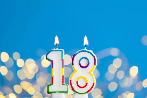 Číslo 18 narozeninová svíčka proti jasném osvětlení a — Stock fotografie