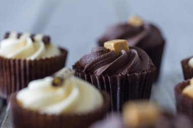Bir çikolata, karamel ve vanilya krema ile dekore Cupcakes