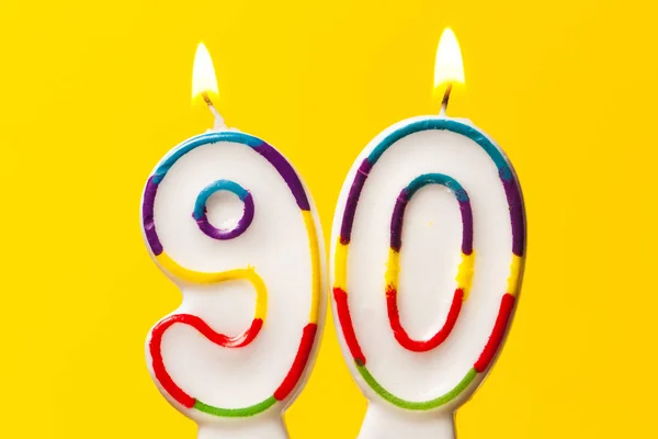 Numer 90 urodziny celebracja świeca przed jasnym żółtym ba — Zdjęcie stockowe