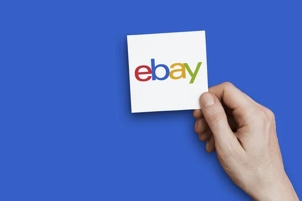 ロンドン、英国 - 2018年10月30日:手はEbayのロゴを保持しています。Ebayはオンラインマーケットプレイスです — ストック写真