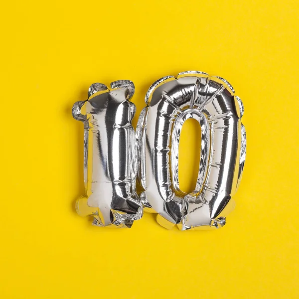 Silver folie nummer 10 firande ballong på en ljusgul BAC — Stockfoto