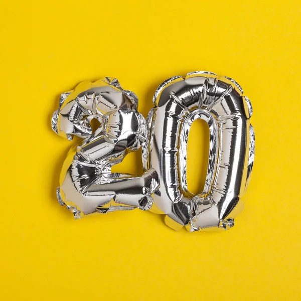 Silberfolie Nummer 20 Feier Ballon auf einem leuchtend gelben bac — Stockfoto