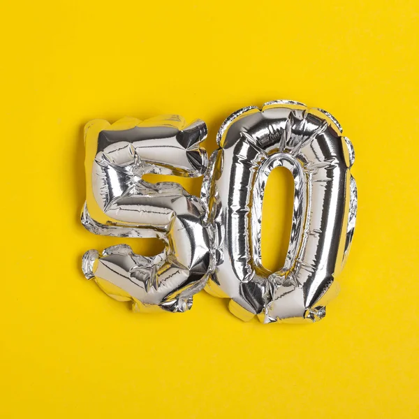 Pellicola d'argento numero 50 palloncino celebrazione su un bac giallo brillante — Foto Stock