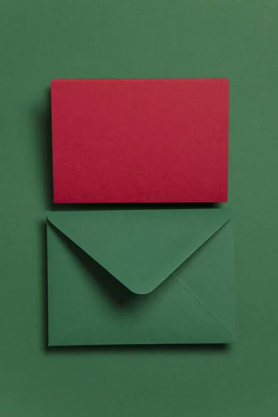 Prázdná červená karta s obálkou na zelené papíru šablona Vánoční karty — Stock fotografie