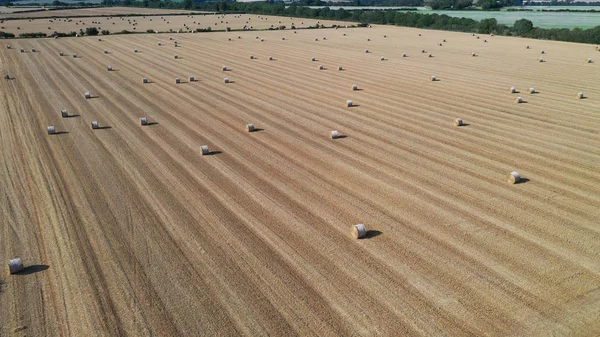 Kırsal manzara üzerinde havadan görünümü. Güneşli bir günde bir çiftlik tarlasında saman balyaları — Stok fotoğraf