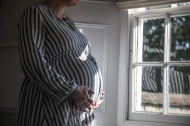 Bir pencere tarafından syanding bir prgnant kadın