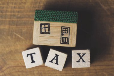 Ahşap bloklardan yapılmış vergi kelime ile ev modeli. Ev finansmanı 