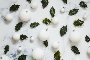 Noel düzeni beyaz bir marbl üzerinde şenlikli holly yapraklarından yapılmış