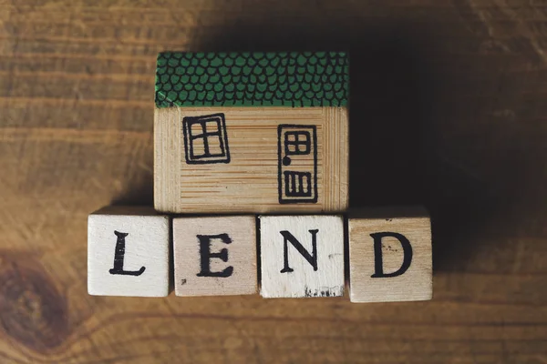 Έννοια του δανεισμού στο σπίτι. Μοντέλο σπιτιού με λόγια από τον γούντε — Φωτογραφία Αρχείου