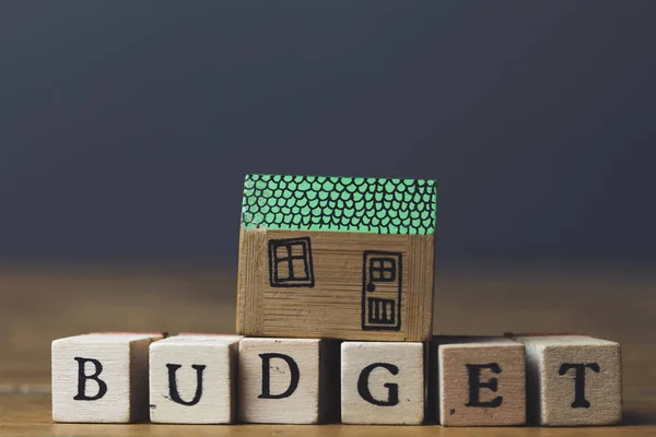 Hem budget koncept. Hus modell med budget ord av trä — Stockfoto