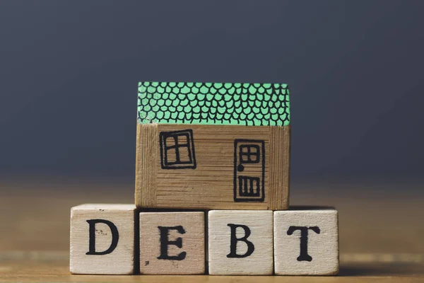 Conceito de dívida doméstica. Modelo de casa com palavra da dívida feita de madeira b — Fotografia de Stock