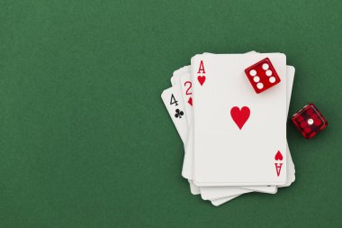 Yeşil arka planda poker kartları ve zarlar.