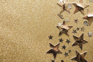 Altın parıltılı arka plan üzerinde Altın yıldız ışıltı parti konfeti