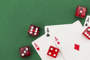 Yeşil arka planda poker kartları ve zarlar.