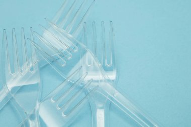Plastik çatal mavi bir arka plan üzerinde düzenlenmiş. Plastik oldu