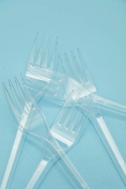 Plastik çatal mavi bir arka plan üzerinde düzenlenmiş. Plastik oldu
