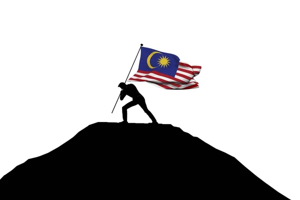 Malaysia flag being pushed into mountain top by a male silhouett — Stock Photo, Image