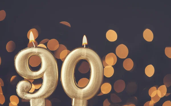 Gold number 90 celebration candle against blurred light backgrou — Stock Photo, Image