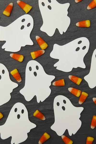 Tło Halloween z duchami i cukierków kukurydzy na łupku ciemny — Zdjęcie stockowe