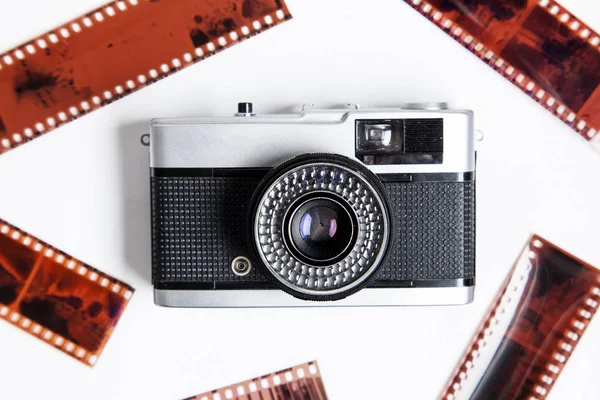 Vintage film kamera ve beyaz bir arka plan üzerinde negatifleri — Stok fotoğraf