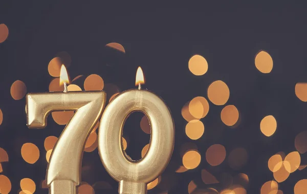Guld nummer 70 firande ljus mot suddig ljus bakgrun — Stockfoto