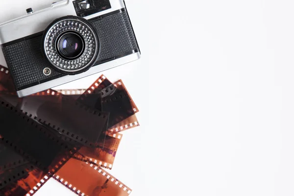 Vintage film camera and negatives on a white background