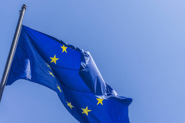 European union flag flying against a blue sky background