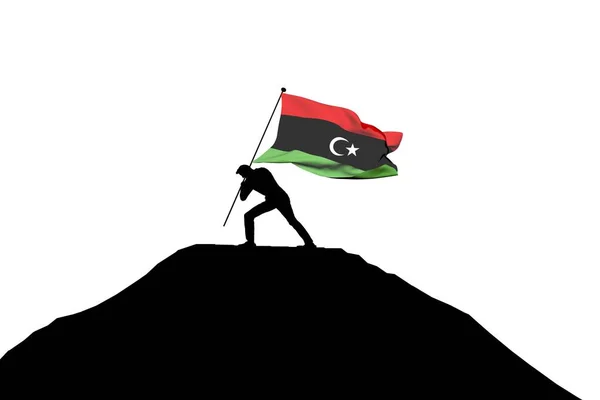男性のシルエットで山頂に押し込まれるリビア国旗. — ストック写真