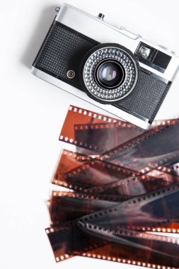 Vintage film kamera ve beyaz bir arka plan üzerinde negatifleri