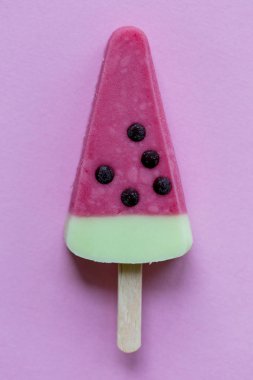 Karpuz şeklinde yaz buz lolly bir pastel pembe arka plan üzerinde