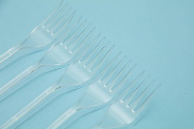Plastik çatal mavi bir arka plan üzerinde düzenlenmiş. Plastik oldu