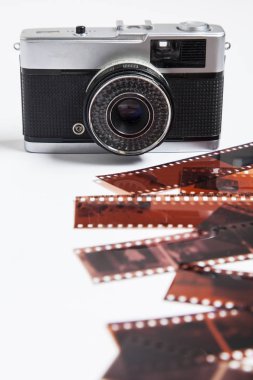 Vintage film kamera ve beyaz bir arka plan üzerinde negatifleri