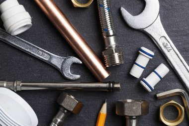 Sıhhi tesisat konsepti. karanlık bir kayrak bakground üzerinde araçları ve borular