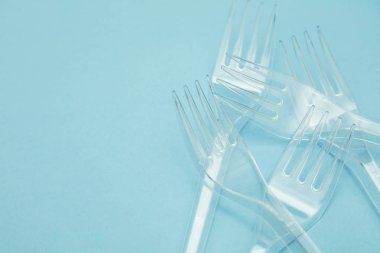 Plastik çatal mavi bir arka plan üzerinde düzenlenmiş. Plastik oldu