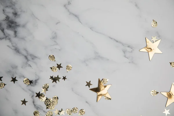 Altın yıldız ışıltı parti konfeti mermer düz döşeme arka plan — Stok fotoğraf