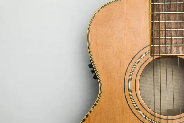 Düz bir arka plan karşı ahşap akustik gitar