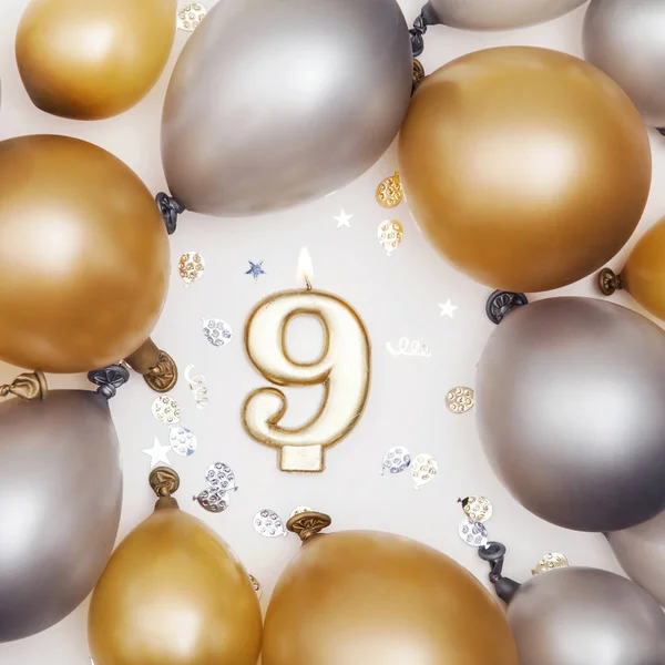 День рождения номер 9 свеча с золотым и серебряным шариком — стоковое фото
