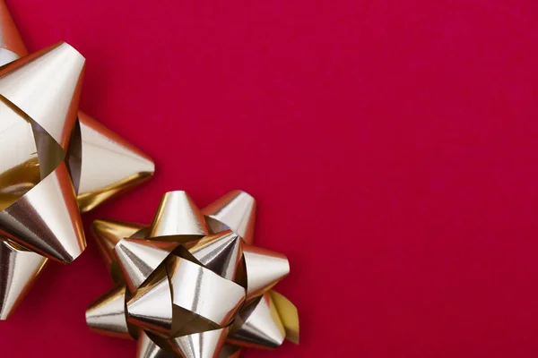 Metallic gift bow on a red background — Stock Photo, Image