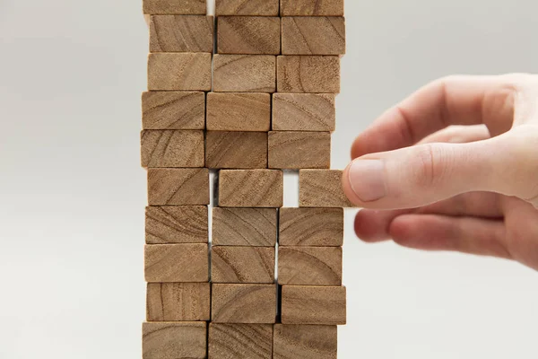 Male hand stacking wooden blocks. Business development and growt