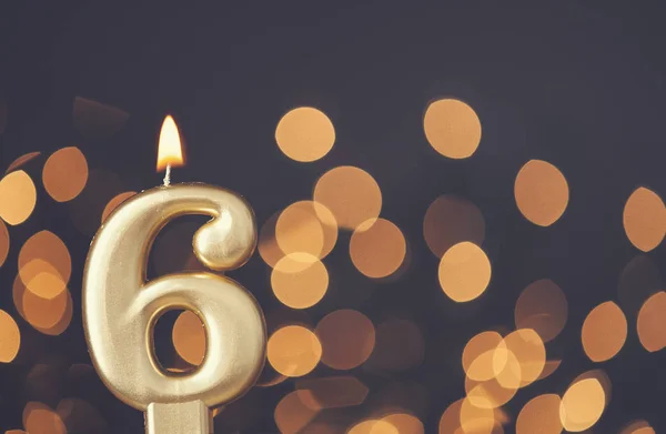 Zlaté číslo 6 oslava svíčky proti rozmazané světelné backgroun — Stock fotografie
