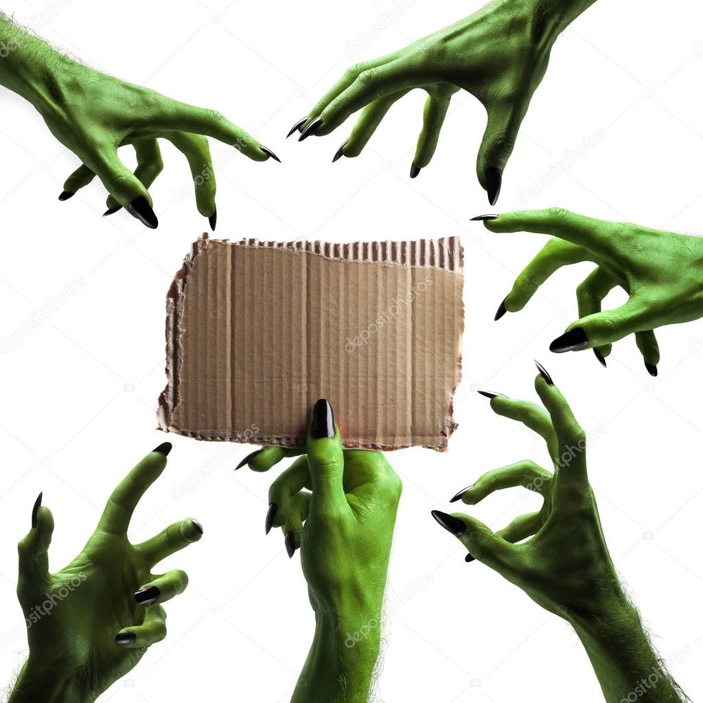 Halloween green witches or zombie monster hand holding a blank s